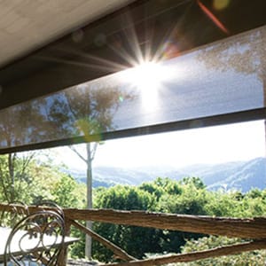 Rustic porch overlooking the mountains with brown roller shade