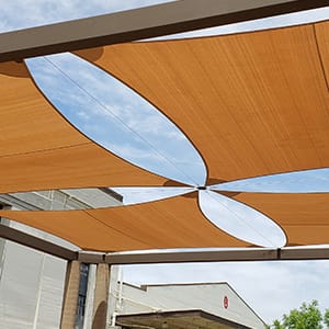 Four piece tan shade sail above a patio