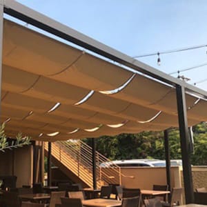 Restaurant patio with tan slide waire canopy covering it