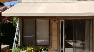 Fabric awning shading a residential patio. 11